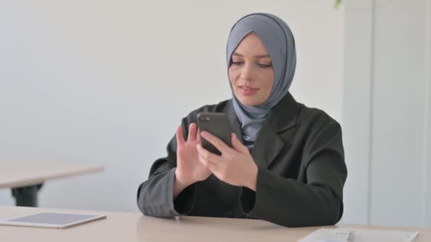 仕事でスマートフォンを使うムスリムビジネスウーマン — ストック動画