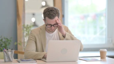 Young Businessman with Headache Working on Laptop