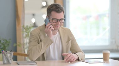 Genç işadamı akıllı telefondan konuşuyor.