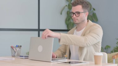 Genç İş Adamı Ofise Geldi ve Dizüstü bilgisayarla Çalışmaya Başladı