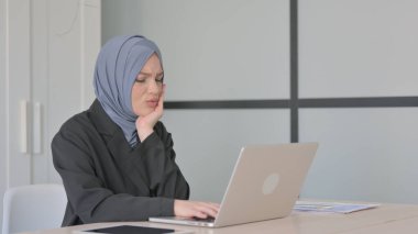 Müslüman İş kadını dizüstü bilgisayar ve enfeksiyon üzerinde çalışırken diş ağrısı çekiyor