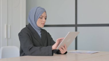 Tablet PC kullanan neşeli Müslüman İş kadını