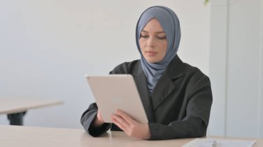 Tablet PC kullanan neşeli Müslüman İş kadını