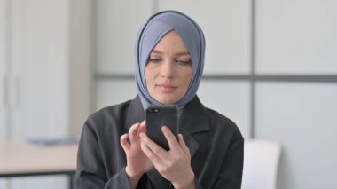 Smartphone kullanan Müslüman İş kadınının Portresi
