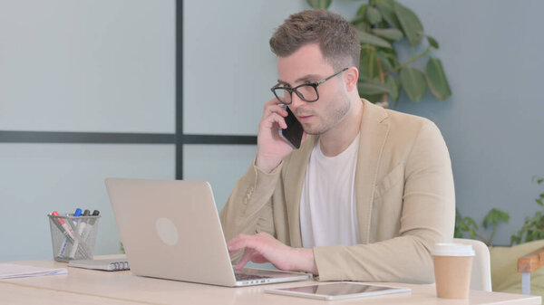Young Businessman Talking on Phone at work