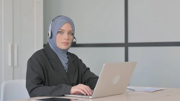 Μουσουλμάνα Επιχειρηματίας Ακουστικά Κοιτάζοντας Προς Την Κάμερα Στο Τηλεφωνικό Κέντρο — Φωτογραφία Αρχείου