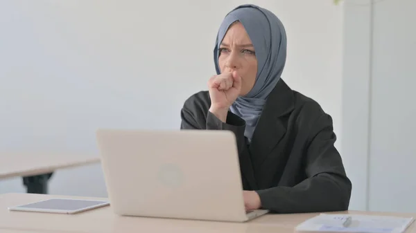 在笔记本电脑上咳嗽的穆斯林女商人 — 图库照片