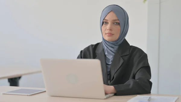Muslimische Geschäftsfrau Arbeitet Laptop Und Blickt Die Kamera — Stockfoto