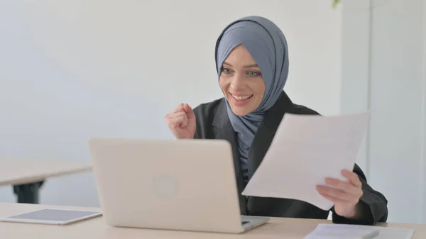 穆斯林女商人庆祝在笔记本电脑和文件 文书工作上的成功 — 图库照片