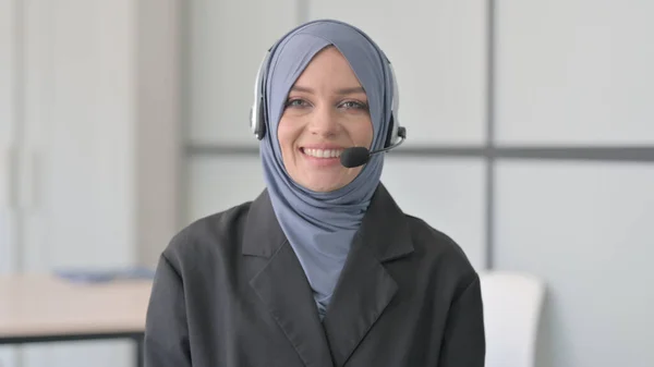 在呼叫中心相机前佩戴耳机微笑的穆斯林女商人 — 图库照片