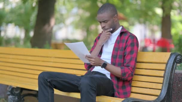 Fiatal Afrikai Férfi Olvasási Dokumentumok Miközben Szabadban — Stock videók