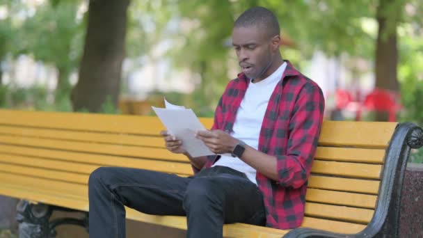 Ung Afrikansk Man Firar När Läser Kontrakt Utomhus — Stockvideo