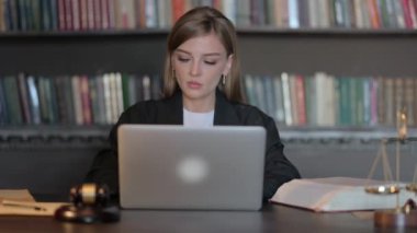 Dizüstü bilgisayarda çalışan genç bayan avukat.