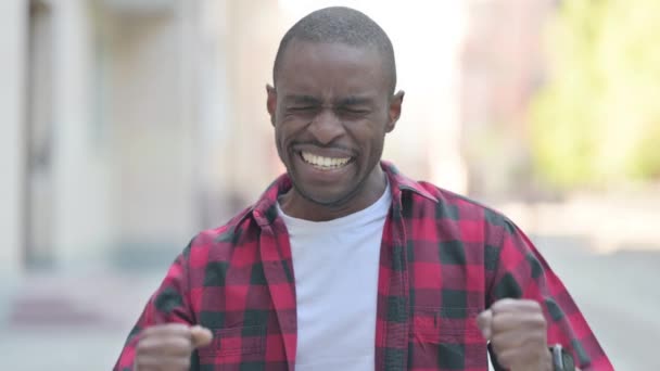 成功を祝う興奮した若いアフリカ人男性の屋外肖像画 — ストック動画