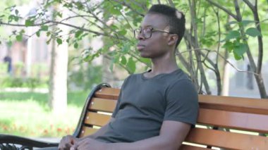 Açık havada oturan Afrikalı Adam 'dan Başparmaklar Yukarı