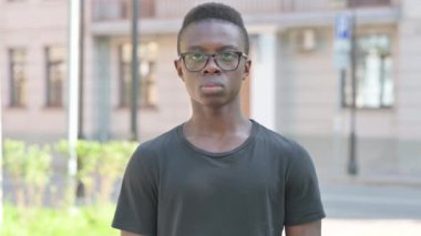 Kameraya bakan gülümseyen genç Afrikalı 'nın açık hava portresi