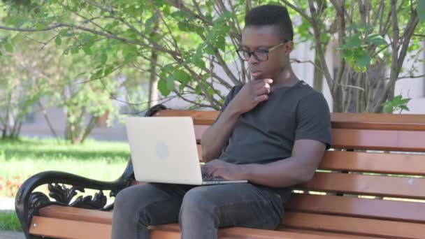 Homem Africano Jovem Pensando Trabalhando Laptop Outdoor — Vídeo de Stock