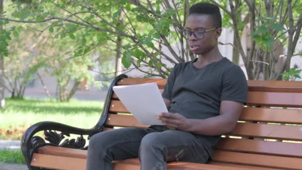 Jonge Afrikaanse Man Voelt Zich Van Streek Tijdens Het Lezen — Stockvideo