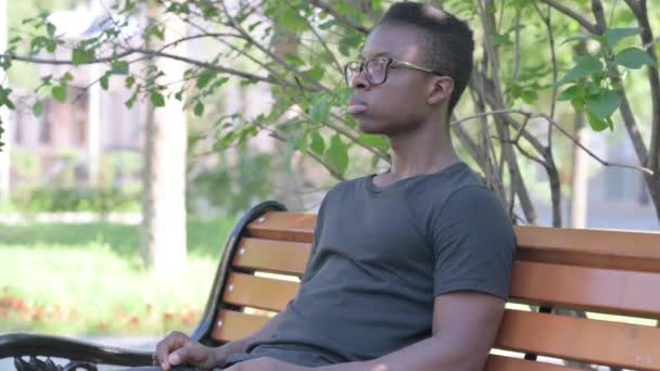 Grave Joven Africano Hombre Sentado Aire Libre Mirando Cámara — Vídeos de Stock