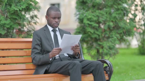 Африканский Бизнесмен Празднует Время Чтения Документов Открытом Воздухе — стоковое видео