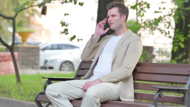 Müder Junger Mann Sitzt Mit Kopfschmerzen Freien — Stockvideo