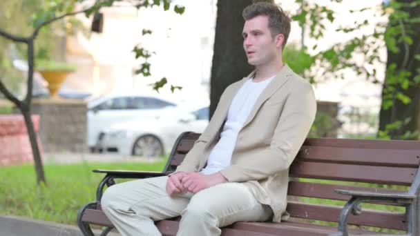 Müder Junger Mann Sitzt Mit Nackenschmerzen Freien — Stockvideo