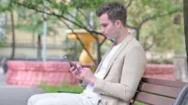 Smartphone Outdoor kullanan sıradan bir genç adam görüntüsü