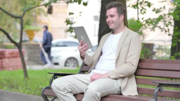 Nenucený Mladý Muž Dělá Video Chat Tabletu Zatímco Sedí Venku — Stock video