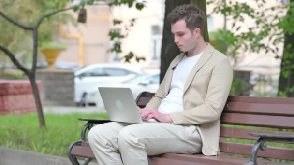 Nenucený Mladý Muž Pomocí Notebooku Bolestí Zad Při Sezení Venku — Stock video