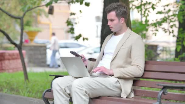 Nenucený Mladý Muž Mluví Telefonu Pomocí Notebooku Venkovní — Stock video