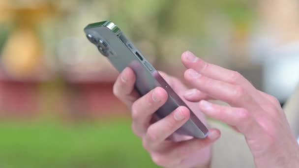 Närbild Casual Young Man Bläddrar Smartphone Medan Sitter Utomhus Bänk — Stockvideo