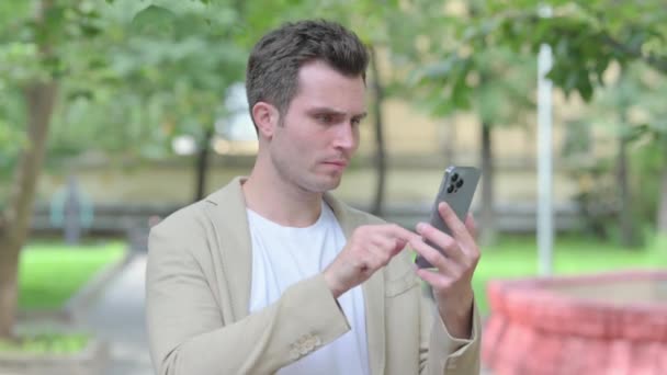 Расстроенный Случайный Молодой Человек Получает Шок Смартфоне Открытом Воздухе — стоковое видео