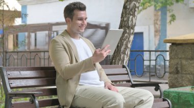 Tablet 'te Görüntü Sohbeti Yapan Genç Adam Bir Benç' te Otururken