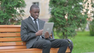 Afrikalı İş Adamı Tablet 'te Görüntü Sohbeti Yaparken Bir Bençte Otururken