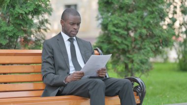 Afrikalı İşadamı Dışarıda Otururken Belgeleri Okurken