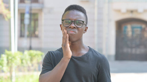 Outdoor Portrait of Young African Man with Toothache