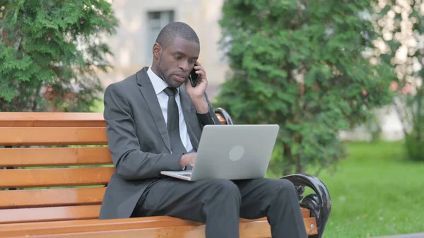 African Businessman Talking on Phone at work