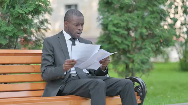 African Businessman Feeling Upset while Reading Contract Outdoor
