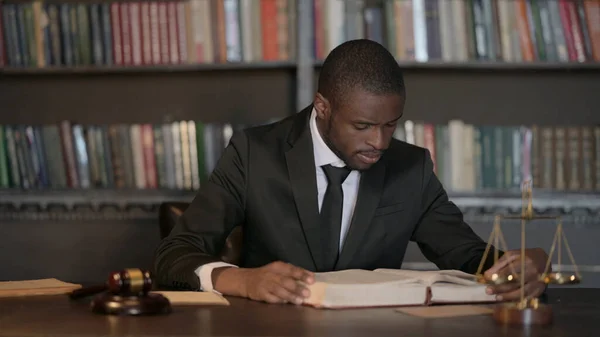 African Male Lawyer Reading Law Book in Office