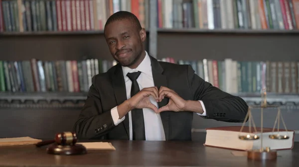 Smiling African Male Lawyer with Heart Sign