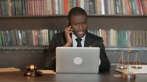African Male Lawyer Talking on Phone with Client