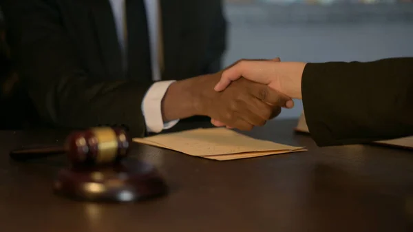 Male and Female Business People Shaking Hands After Legal Agreement