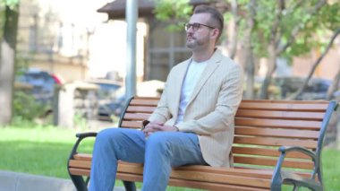 Orta yaşlı adam ayağa kalkıyor ve Bench 'i dışarıda bırakıyor.