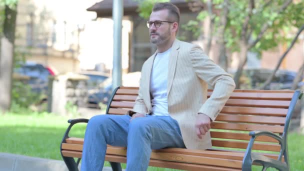 Hombre Mediana Edad Sentado Aire Libre Con Dolor Espalda — Vídeos de Stock