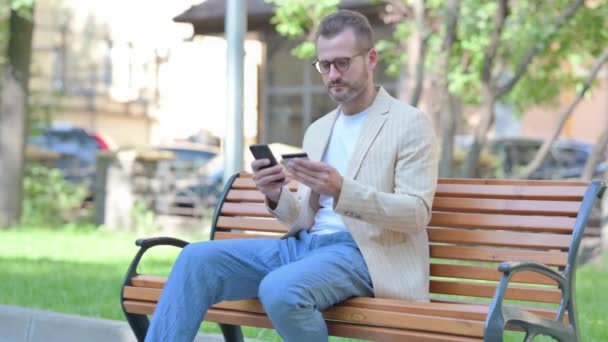 Středověký Muž Dělá Line Nakupování Přes Telefon Zatímco Sedí Venku — Stock video