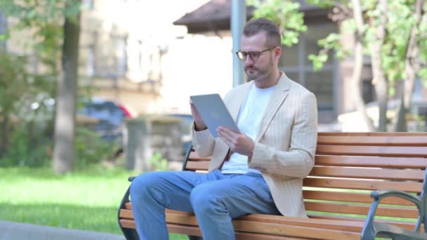Homem Meia Idade Perturbado Pela Perda Tablet Enquanto Sentado Livre — Vídeo de Stock