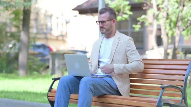 Człowiek Średnim Wieku Korzystanie Laptop Bólem Pleców Podczas Siedzenia Zewnątrz — Wideo stockowe