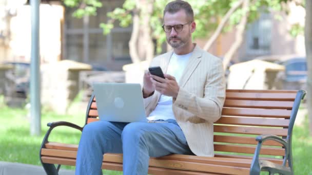 Hombre Mediana Edad Que Trabaja Ordenador Portátil Teléfono Inteligente — Vídeo de stock
