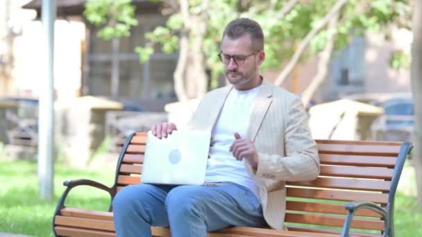 Чоловік Середнього Віку Залишає Лавку Відкритому Повітрі Після Роботи Ноутбуці — стокове відео
