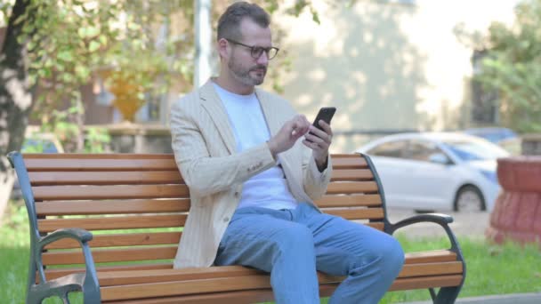 Homem Casual Moderno Chocado Por Perda Smartphone Enquanto Sentado Livre — Vídeo de Stock